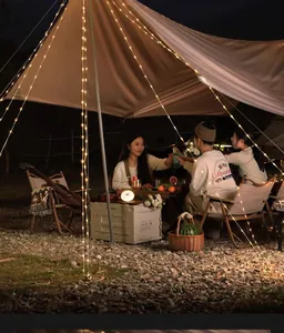 Outdoor camping atmosphere string lights illuminating a night picnic under a tent canopy