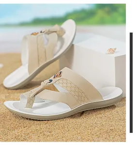 Gros plan de tongs de plage beiges pour hommes avec brides imprimées et semelles souples