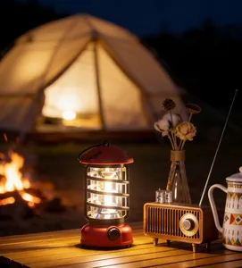 Vintage red rechargeable LED camping lantern on a wooden table in a night campsite