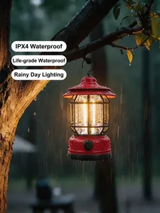 Retro red camping lantern with warm COB light hanging on a tree in the rain