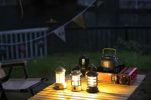Warm and cozy night camping scene with vintage LED lanterns on a wooden table