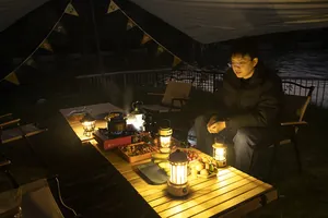 Cozy night camping scene featuring retro portable lanterns on a wooden table outdoors