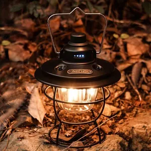 Vintage black rechargeable LED camping lantern with warm light in outdoor forest setting