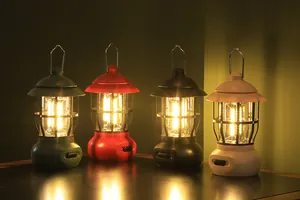 Détail de quatre lanternes de camping LED rétro de différentes couleurs à lumière chaude
