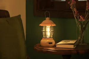 Warm ambient shot of a retro rechargeable camping lantern placed on a rustic wooden table.