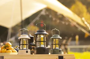 Three vintage style camping lanterns on a wooden table in a sunset outdoor setting