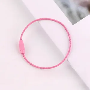 Close-up of a pink coated steel wire loop with a screw fastener for DIY keychains.