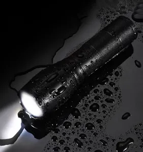 Gros plan d'une lampe de poche LED rechargeable et étanche avec détails de gouttes d'eau