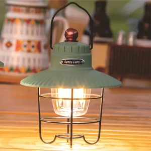 Portable vintage green LED camping lantern with warm glow on rustic wooden table