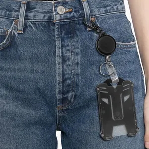 Close-up of retractable badge reel and heavy-duty ID card holder attached to denim jeans
