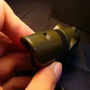 Macro detail showing the structure of 7-in-1 army green multifunctional survival whistle