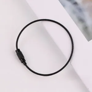 Detail view of a black coated steel wire keychain ring with a secure screw lock connector.
