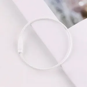 Macro detail view of a white painted steel wire keychain ring with secure screw closure mechanism