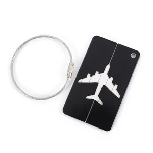 Detail view of a black aluminum luggage tag featuring a sleek airplane cutout and steel wire loop.