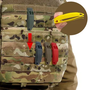 Détail en gros plan de sifflets tactiques MOLLE sur un équipement de camouflage militaire