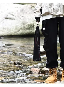 Portable black mesh storage bag for aluminum folding trekking poles in outdoor setting.
