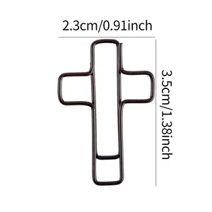 Dettaglio graffetta in metallo nero a forma di croce, dimensioni 2,3 cm x 3,5 cm.