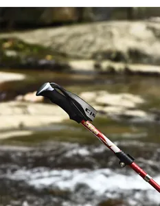 Detailed view of an ergonomic trekking pole handle with a red telescopic aluminum shaft