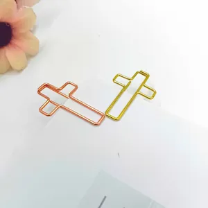 Dettaglio di graffette metalliche a forma di croce color oro e oro rosa