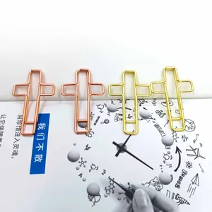 Dettaglio di graffette creative in metallo a forma di croce in oro e oro rosa