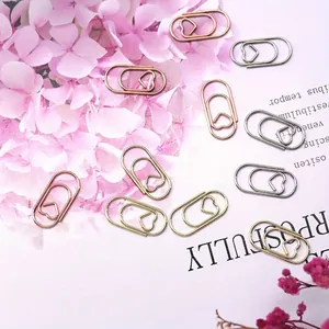 Vista dettagliata di graffette a forma di cuore in oro rosa, oro e argento per ufficio.