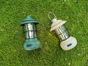 Vintage style camping lanterns in olive green and beige colors on natural grass