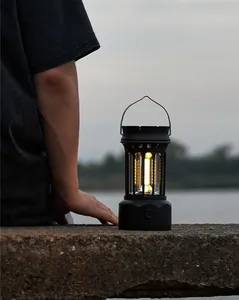 Vintage black camping lantern with warm COB light in a lakeside outdoor setting