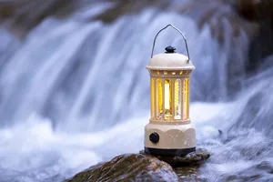 Vintage waterproof camping lantern with warm COB light by a forest waterfall