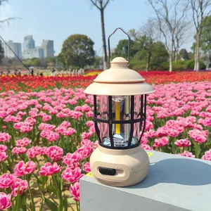 Retro beige camping lantern placed in a field of blooming pink tulips for outdoor ambiance