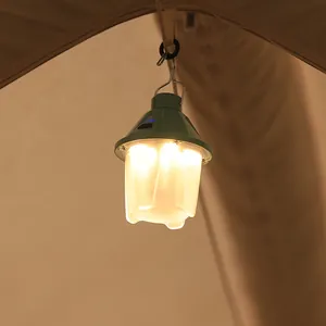 Vintage green pinecone LED camping lantern hanging in a tent for warm outdoor lighting.