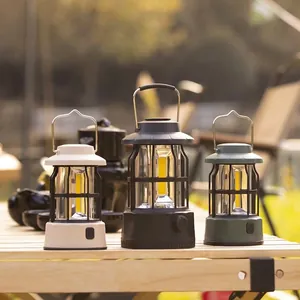 Retro rechargeable LED camping lanterns in three colors on a wooden table outdoors