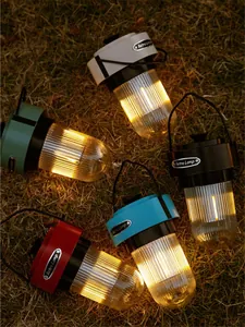 Portable rechargeable LED retro camping lanterns in multiple colors on outdoor grass