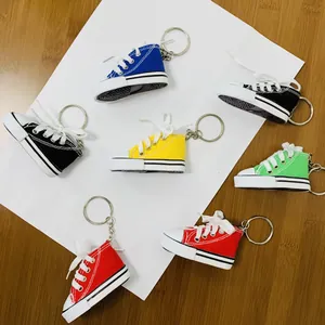 Macro view of colorful mini canvas sneaker keychains arranged on a white background