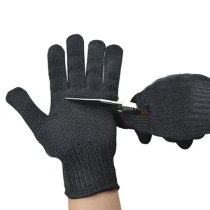 Close-up demonstration of level 5 cut-resistant black steel wire gloves tested with a knife