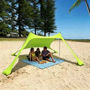 Tenda da spiaggia in Lycra verde lime che offre ombra per un picnic sulla sabbia dorata