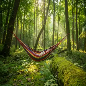 Hamaca de camping doble de lona con rayas de colores colgada en un bosque soleado
