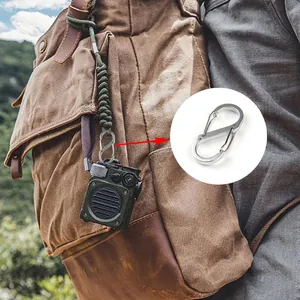 Close-up view of a silver S-shaped carabiner attached to a rugged outdoor backpack