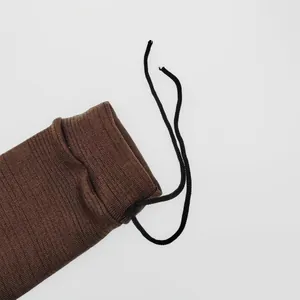 Detailopname van de bruine tactische beschermende sok met zwarte trekkoordsluiting.