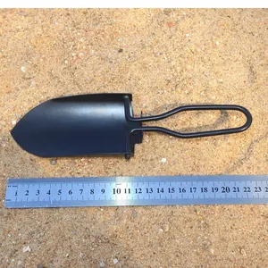 Mini vanga da giardinaggio pieghevole nera con righello di metallo sulla sabbia per scala