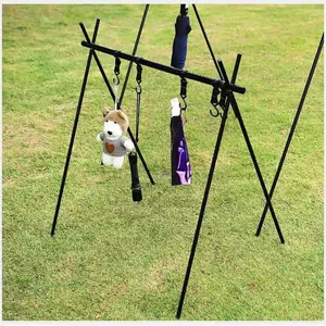 Portable black triangle storage rack for camping shown in a grassy outdoor setting