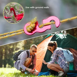 Close-up of a red aluminum camping rope tensioner hook used with an outdoor tent setup
