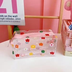 Primer plano de un neceser de PVC transparente con coloridos estampados de margaritas