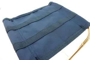 Dettaglio del tessuto in tela navy e del telaio in alluminio dorato della sedia da campeggio