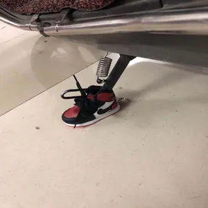 Close-up detail of a mini sneaker decorative cover protecting a motorcycle kickstand