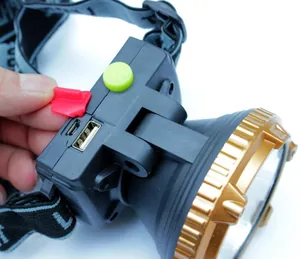 Detail view showing dual USB charging ports and green power button on rechargeable LED headlamp