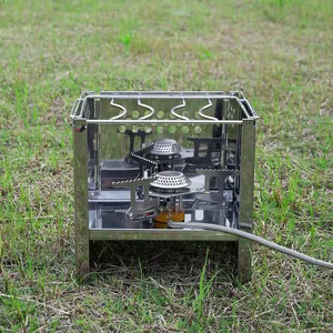 Fornello da campeggio portatile quadrato in acciaio inox su erba verde all'aperto.
