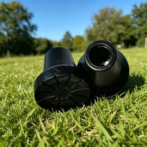 Detailed view of durable black non-slip rubber tips for walking sticks on green grass