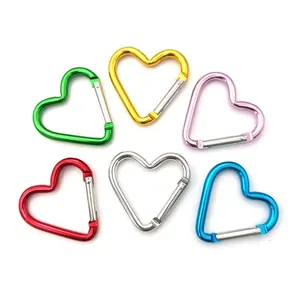Macro view of six colorful heart-shaped carabiners arranged on white background.
