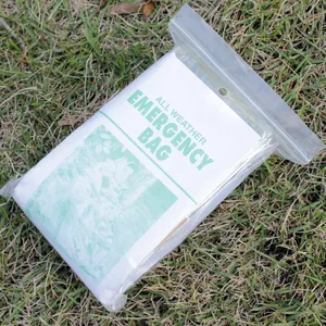 Macro view of the silver emergency sleeping bag inside a clear weatherproof plastic bag.