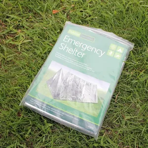 Detailed view of Outdoor Essentials emergency shelter package on grass.